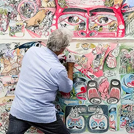Michael Nicoll Yahgulanaas working on an installation of his Haida Manga artwork